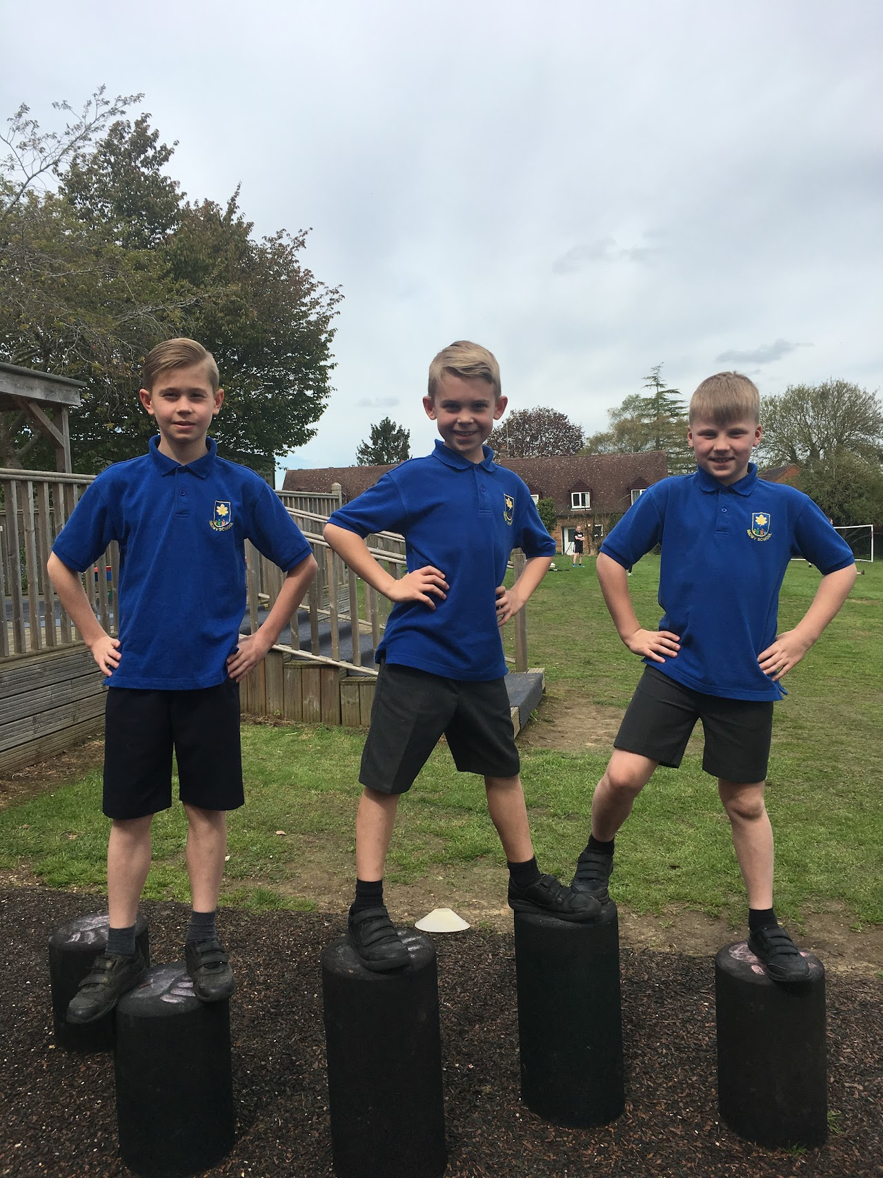 3 pupils wearing blue Badby polo t-shirts and grey shorts